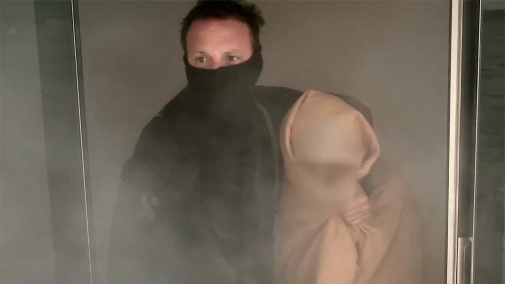 A member of Phantom Rescue escorts a child sex trafficking victim out of a building.