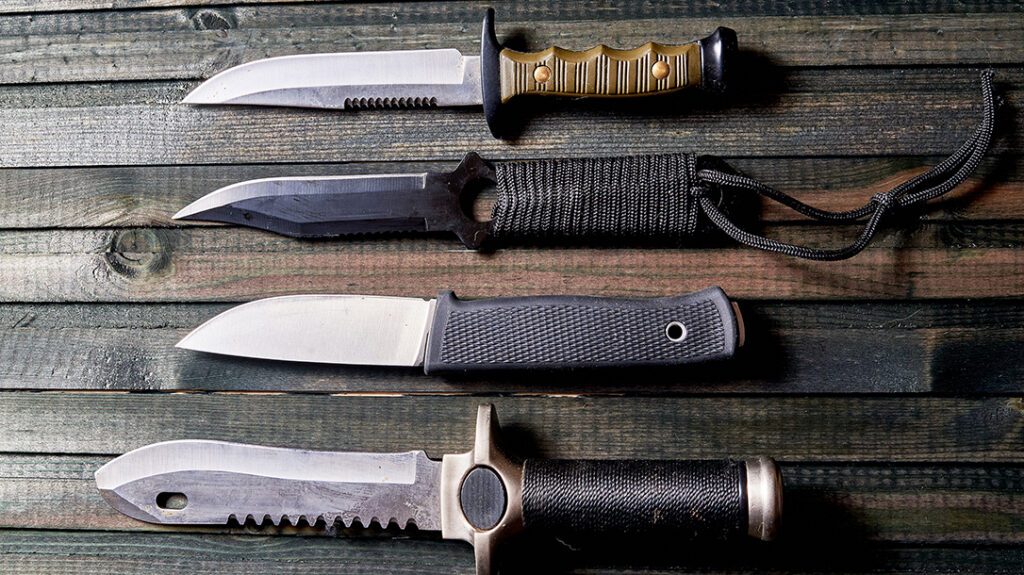 A set of knives on a dark wooden background