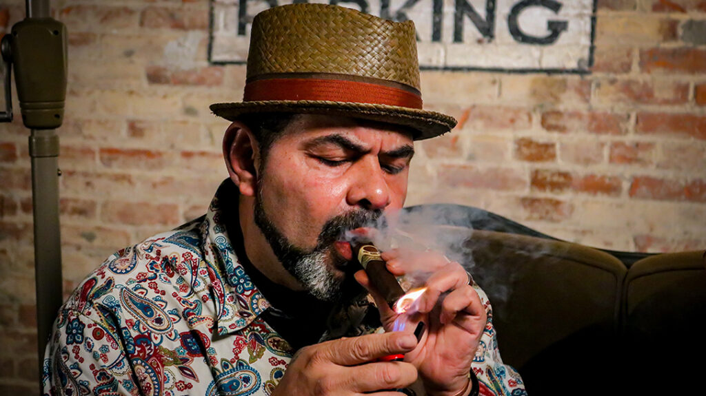 Gently puff on the cigar until the smoke rolls.