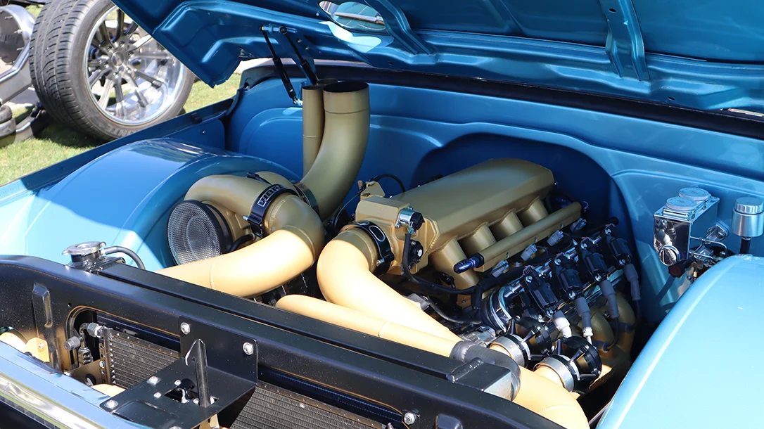 A turbo-charged engine bay resting in a classic Chevy.