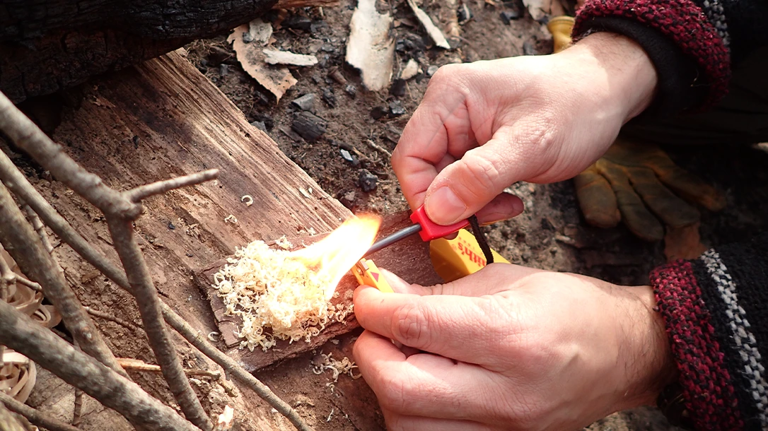 Step 2 of the Pull-Back technique shows the stationary carbide sharpener and the author pulling the Ferro rod back against the striker, producing hot sparks on the tinder.