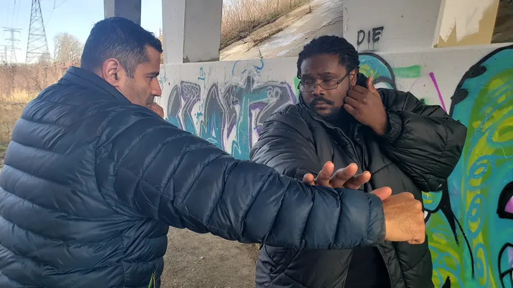 Thomas attempts a punch, Kysean open-palm blocks it outward.
